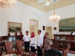 Baiq Nuril, disaksikan oleh Presiden Joko Widodo menerima salinan amnesti dari Menkumham Yasonna Laoly, di Istana Kepresidenan Bogor, Bogor, Jumat, 2 Agustus 2019. (Foto: VOA/Ghita)