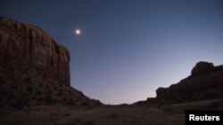 FILE - The moon glows over Indian Creek in the northern portion of Bears Ears National Monument, Utah, Oct. 29, 2017. 