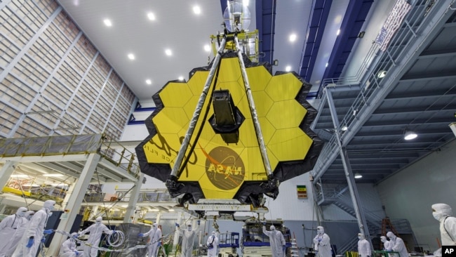 In this April 13, 2017 photo provided by NASA, technicians lift the mirror of the James Webb Space Telescope using a crane at the Goddard Space Flight Center in Greenbelt, Md. (Laura Betz/NASA via AP)