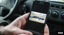 Tomascz, one of the Assothalom border guards shows a picture of some of the migrants his five strong team have caught. (VOA/J. Owens)