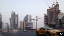 FILE - A sports car drives through downtown Doha, July 10, 2017. 