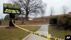 Crime scene tape is used around Great Mills High School, the scene of a shooting, March 20, 2018, in Great Mills. A student with a handgun shot two classmates inside the school before he was fatally wounded during a confrontation with a school resource officer, a sheriff said. 
