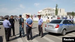 Investigadores y miembros de fuerzas de seguridad se reunieron cerca de la embajada china en Bishkek, Kirguistán, el martes, 30 de agosto de 2016.
tors, Interior Ministry officers and members of security forces gather near the site of a bomb blast outside China's embassy in Bishkek, Kyrgyzstan, August 30, 2016.