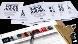FILE - Job applications and information on U.S. clothing retailer GAP are seen on a table during a job fair at a shopping center in Miami, Florida, Oct. 6, 2015.