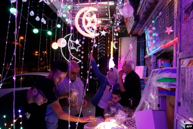 Palestinians check a shop selling Ramadan lights in the old city of Jerusalem, May 4, 2019, as Muslims around the world prepare for the announcement of the fasting month of Ramadan which is expected to start on May 5 or 6 depending on the crescent moon.