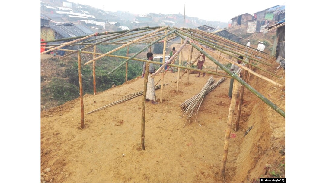 Some Rohingyas are building the structure of a house for a refugee family on the slope of a hill in Tengkhali refugee camp, Cox's Bazar, Bangladesh.