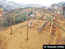 Some Rohingyas are building the structure of a house for a refugee family on the slope of a hill in Tengkhali refugee camp, Cox's Bazar, Bangladesh.