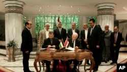Pejabat Senior Fatah, Azzam al-Ahmad, tengah kanan, dan Perwakilan Hamas', Saleh al-Arouri, tengah kiri, menandatangani perjanjian rekonsiliasi dalam upacara singkat di kompleks Intelijen Mesir di Kairo, Mesir, Kamis, 12 Oktober 2017. 