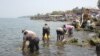 Des hommes et des femmes puisent l’eau du lac Kivu, à Goma, pour aller la vendre dans des quartiers non ou mal desservis par la Régie de distribution et traitement d’eau du Nord-kivu.