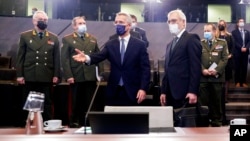 NATO Secretary General Jens Stoltenberg, center, and Russia's Deputy Foreign Minister Alexander Grushko, fourth right, arrive for the NATO-Russia Council at NATO headquarters, in Brussels, Jan. 12, 2022. 