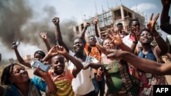Les manifestants crient à côté d'un barrage routier au milieu de l'avenue principale de Beni lors d'une manifestation contre le report des élections sur le territoire des Beni et de la ville de Butembo le 27 décembre 2018.