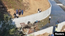 Des experts médico-légaux de la police turque examinent l'épave d'un camion transportant des migrants après son accident à Izmir, en Turquie, le 14 octobre 2018.
