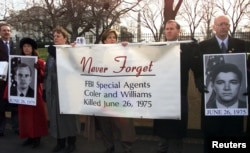 FILE - FBI agents hold a banner in front of the White House during an FBI rally, Dec. 15, 2000. The rally was held to show opposition to any consideration by then-President Bill Clinton to grant clemency to Leonard Peltier, convicted of murdering two FBI agents.