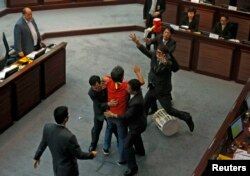 绰号“长毛”的社民连议员梁国雄在立法会上扔东西而被警卫人员阻止。最近梁国雄在过境时因不肯脱下写有“毋忘六四”、“公民提名”、“占领中环”等字句的上衣而被阻止进入中国大陆