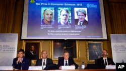 Akademi Sains Kerajaan Swedia Torsten Persson mengumumkan pemenang Nobel Ekonomi untuk tiga ekonom Amerika, yang ditayangkan di layar lebar (dari kiri: Eugene Fama, Lars Peter Hansen and Robert Shiller) dalam konferensi pers di Stockholm (14/10). 