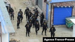 FILE - Members of the Rapid Action Battalion stand guard at the scene of an operation to storm an alleged militants hideout in Dhaka, Bangladesh, April 29, 2019. 