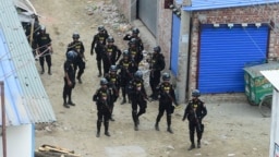 FILE - Members of the Rapid Action Battalion stand guard at the scene of an operation to storm an alleged militants hideout in Dhaka, Bangladesh, April 29, 2019. 