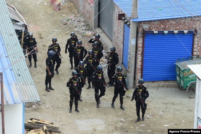 FILE - Members of the Rapid Action Battalion stand guard at the scene of an operation to storm an alleged militants hideout in Dhaka, Bangladesh, April 29, 2019.