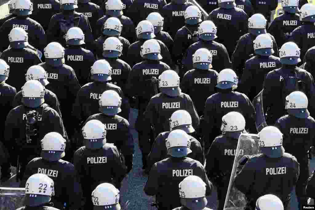 German riot police stand in front of protesters during the G20 summit in Hamburg, Germany.