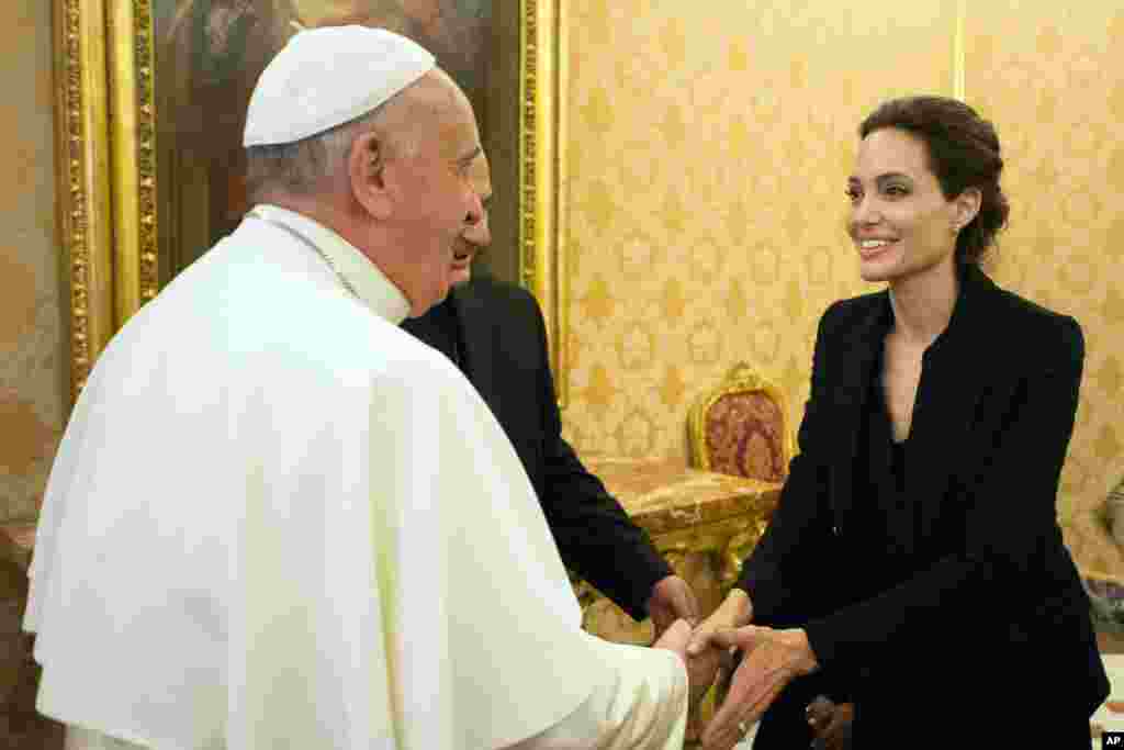 Pope Francis greets Angelina Jolie in the Apostolic Palace at the Vatican after screening her film Unbroken to some Vatican officials and ambassadors.