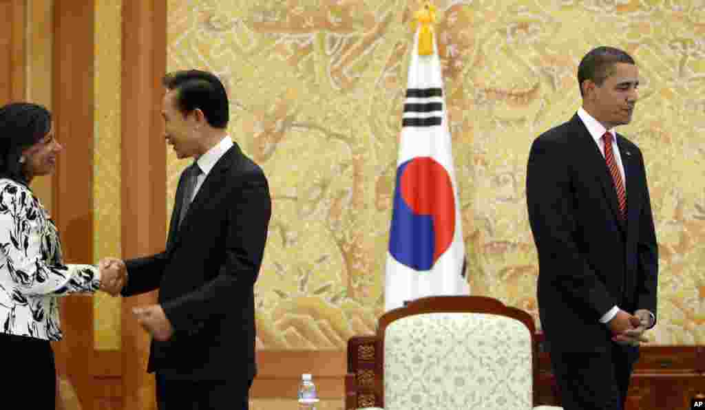 President Barack Obama gets ready to take his seat as South Korean President Lee Myung-bak greets U.S. Ambassador to the U.N. Susan Rice, Blue House in Seoul, South Korea, November 19, 2009. 