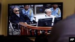 Khieu Samphan, second from right, former Khmer Rouge head of state, and Noun Chea, left, who was the Khmer Rouge's chief ideologist and No. 2 leader, is seen on a screen at the court's press center of the U.N.-backed war crimes tribunal in Phnom Penh, file photo. 