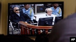 Khieu Samphan, second from right, former Khmer Rouge head of state, and Noun Chea, left, who was the Khmer Rouge's chief ideologist and No. 2 leader, is seen on a screen at the court's press center of the U.N.-backed war crimes tribunal in Phnom Penh, Cam