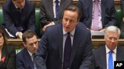 British Prime Minister David Cameron talks to lawmakers inside the House of Commons in London during a debate on launching airstrikes against Islamic State extremists inside Syria, Dec. 2, 2015. 