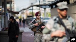 FILE - Members of the National Guard patrol along the Inner Harbor in the aftermath of rioting following Monday's funeral for Freddie Gray, who died in police custody, April 30, 2015, in Baltimore. 