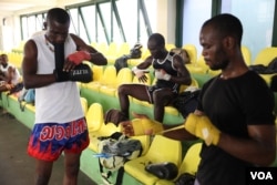 Kickboxers Isaac Aikins (left) and Isaac Commey Doku (center) ready for practice at the gym at a sport stadium near Accra, Ghana, Sept. 10. (Chris Stein/VOA)