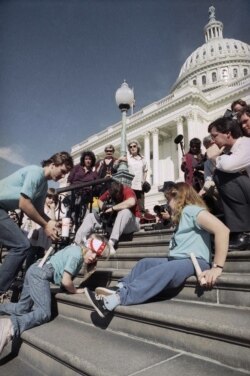 Sekelompok penyandang disabilitas yang dipimpin oleh Jennifer Keelan yang berusia 8 tahun, kiri, merangkak menaiki tangga US Capitol di Washington. (Foto: AP/Jeff Markowitz)