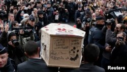 FILE - A White House summit this week is focusing on the international fight against terrorism. Here, pallbearers carry the coffin of terrorist victim Bernard Verlhac, a Charlie Hebdo cartoonist, in Montreuil, near Paris, Jan. 15, 2015. 