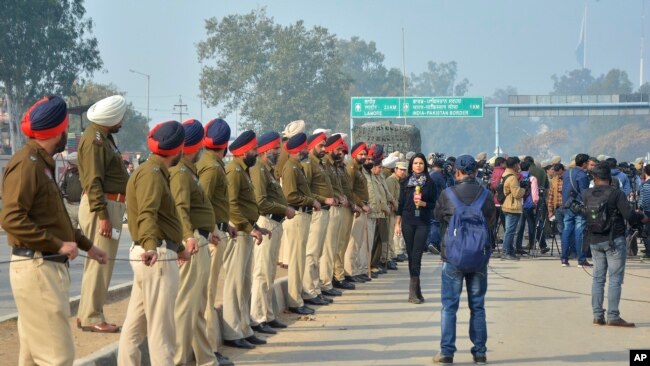 印度警察和媒体人员在印巴边境等待印度飞行员回国。（2019年3月1日）