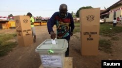 Seorang warga Ghana memasukkan surat suaranya ke kotak suara di salah satu TPS di Kibi, wilayah timur Ghana yang merupakan kubu calon presiden Nana Akufo-Addo dari oposisi Partai Patriotik Baru (NPP) (7/12).