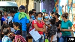 Migrantes venezolanos esperan ser vacunados contra el COVID-19 en el sector La Parada, la zona comercial de la frontera entre Colombia y Venezuela, en Cúcuta, Colombia, el 13 de octubre de 2021. Foto: AFP.