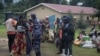 FILE - A Ugandan police officer speaks to a group of asylum seekers from the Democratic Republic of the Congo at a transit center in Kisoro, Uganda, Nov. 10, 2021. Uganda is deploying troops in the DRC in a joint operation against ADF rebels.