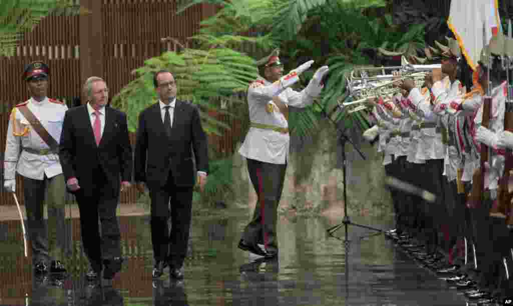 French President Francois Hollande and Cuban President Raul Castro review an honor guard at the Revolution Palace in Havana, Cuba, May 11, 2015.
