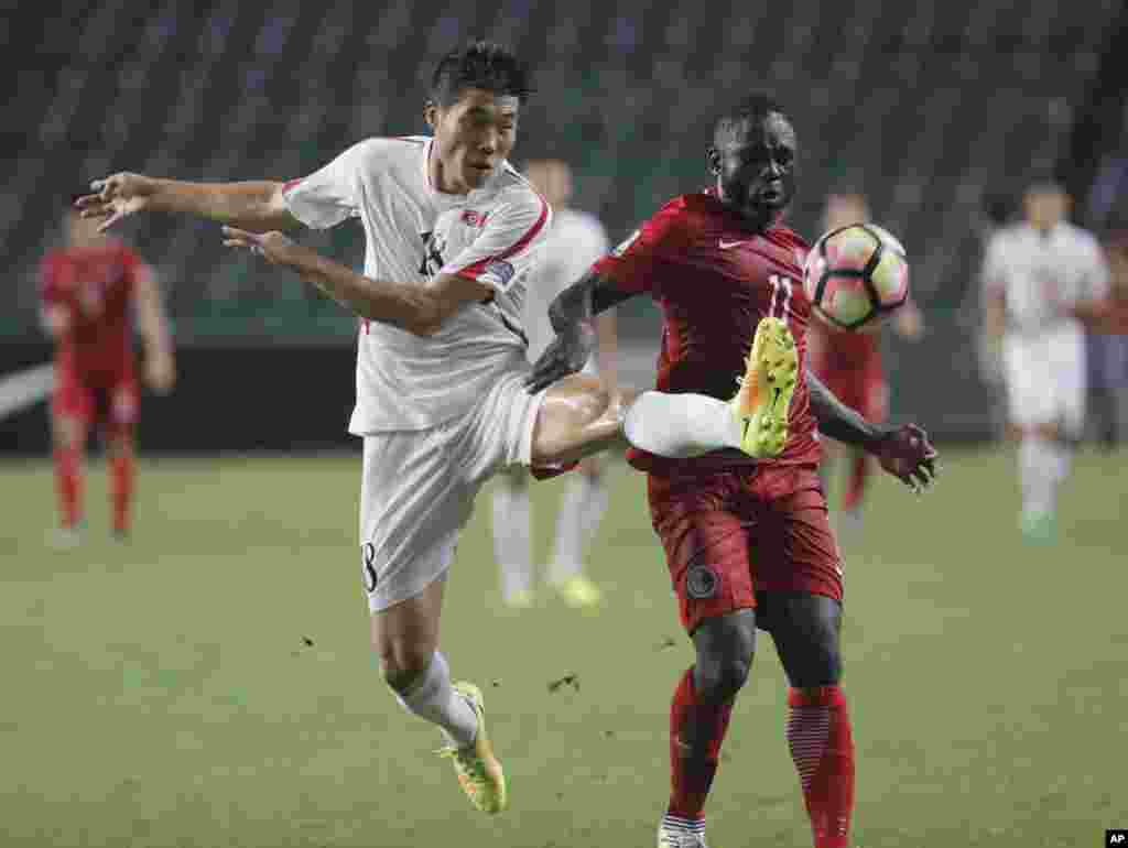 아시아축구연맹 주최 '2019 아시안컵' 예선 경기에서 북한의 리영철 선수(왼쪽)가 홍콩의 고드프레드 카리카리 선수와 공을 다투고 있다.