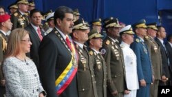 Photo provided by the Miraflores Presidential Palace shows President Nicolas Maduro, second from left, and first lady Cilia Flores during a event marking the 81th anniversary of the National Guard, in Caracas, Venezuela, Aug. 4, 2018. 