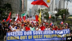 FILE - Protesters march toward the Chinese Consulate, April 9, 2019, in suburban Makati city, Philippines. They are calling on citizens to uphold national sovereignty in the wake of China's alleged occupation of the disputed islands, shoals and reefs in the South China Sea. 