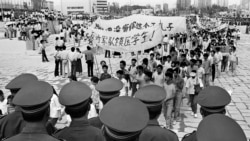 FILE - Chinese police monitor a march by tens of thousands of pro-democracy protesters in the special economic zone of Shenzhen in southern China, May 22,1989. Hundreds of people were killed in Beijing on June 4, 1989, when troops crushed the uprising.