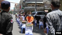 Authorities provide essential food to residents living in Psar Kandal I commune during the country's lockdown in Phnom Penh and Takhmau city, Cambodia, on April 26, 2021. (Kann Vicheika/VOA Khmer)