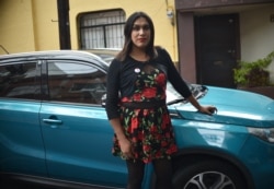 Maria Clemente Garcia (tengah), wanita transgender pertama yang terpilih di Meksiko, berpose di samping mobilnya sebelum memulai kegiatan di Mexico City, 25 Juni 2021. (AFP)