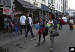 FILE - Venezuelan migrants try to sell cotton swabs and razors near the Central Market in Lima, Peru, Oct. 9, 2018.