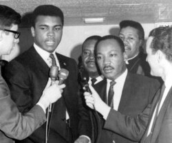 Juara dunia tinju kelas berat Muhammad Ali (kiri tengah) bersama Dr. Martin Luther King,Jr. dalam konferensi pers, 29 Maret 1967. (AP).