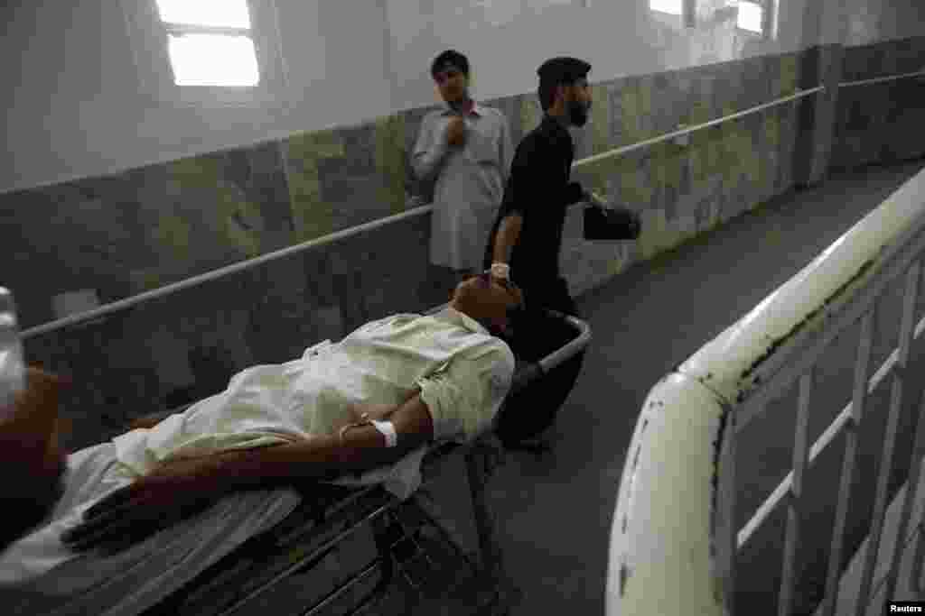 Hospital staff wheel a man, who was injured in a bomb blast, at the Lady Reading Hospital, Peshawar, Pakistan, Sept. 27, 2013.