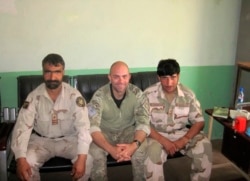 In this undated photo provided by Ryan Brummond, U.S. Special Forces Officer Ryan Brummond, center, is seated next to Mohammad Khalid Wardak, right, in Afghanistan.