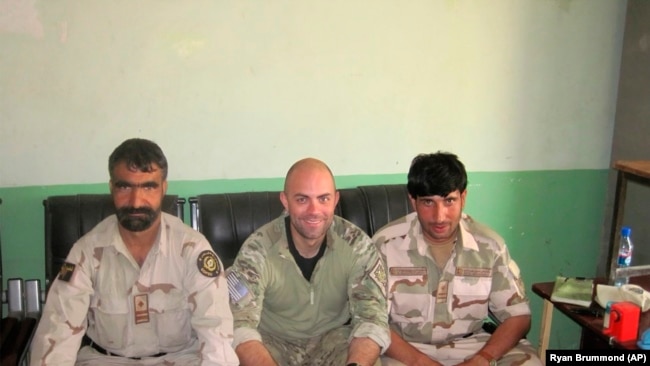 In this undated photo provided by Ryan Brummond, U.S. Special Forces Officer Ryan Brummond, center, is seated next to Mohammad Khalid Wardak, right, in Afghanistan.