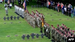Des soldats allemands, canadiens, polonais, français et américains participent à une cérémonie au cimetière allemand de Normandie, le 5 juin 2019 dans le cadre du 75e anniversaire du débarquement allié lors de la Seconde Guerre mondiale.