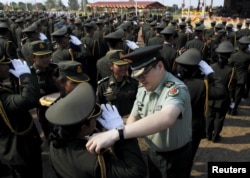 A Chinese army advisor (C) puts rank on Cambodian army graduates during a graduation ceremony at Army Institute in Kampong Speu province March 12, 2015.